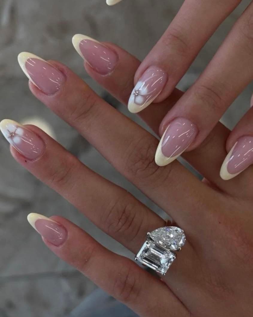Classic white French tips with a delicate flower accent